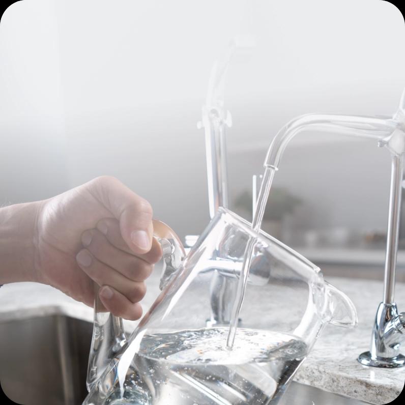 Uso doméstico del grifo: persona sirviéndose agua fresca
